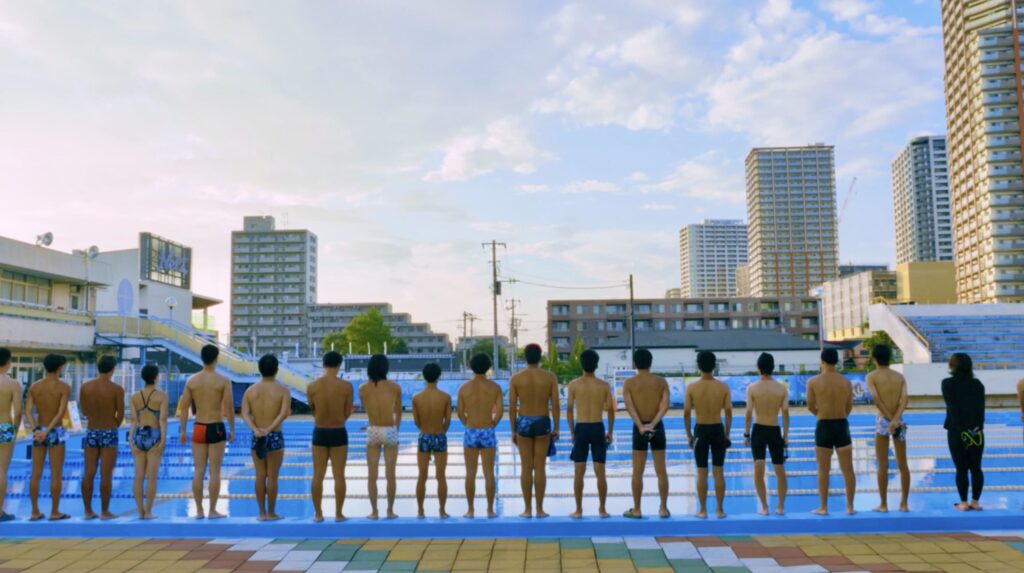 映画『沼影市民プール』のプールサイドに並ぶ人々