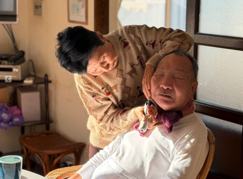 映画『うそがほんとに ほんとがうそに』の場面写真。姉の袴田ひで子さんが弟の巖さんのひげを剃る日常のひとこま
